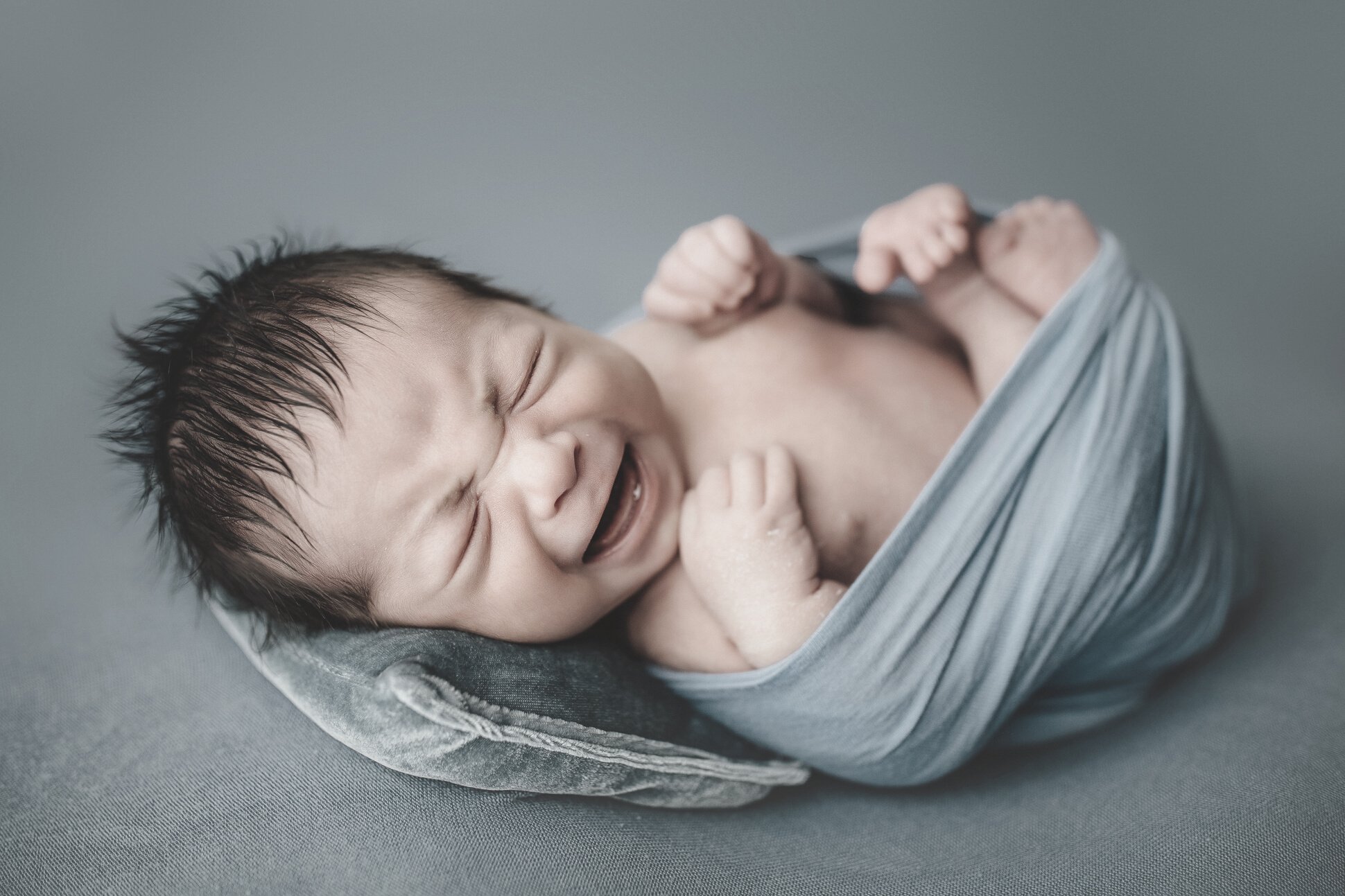 Newborn Portrait of Crying Baby Wrapped in Cloth